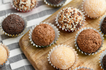 Typical Brazilian sweet brigadeiro. Top view of assorted flavors candies on wooden board. Pattern