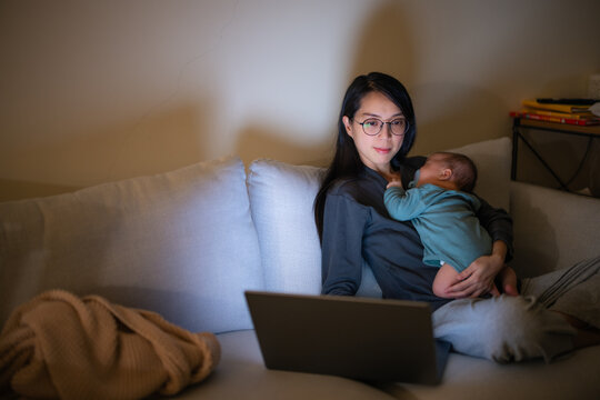 Mother Working While Holding Baby