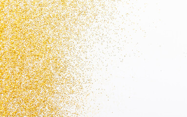 Golden glitter sand texture on white, abstract background. Yellow dusty shimmer decoration, shiny and sparkling frame, top view, copy space. Holidays and glamour concept.