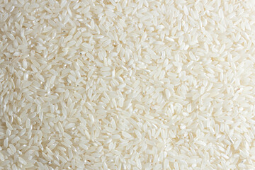 Dry Uncooked White Rice Background - Top View, Flat Lay. Scattered Raw Long Grain Rice. Asian Cuisine and Culture. Healthy Eating Ingredients. Diet Food