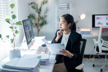 A woman is sitting at a desk with a computer monitor