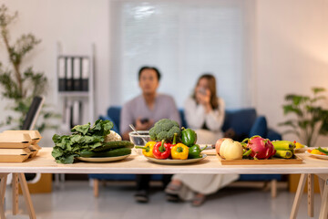 A couple is sitting on a couch in a living room, watching television