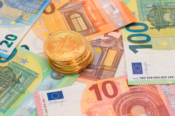 A Stack of Bitcoin Coins on the Euro Banknotes. Money Saving, Cryptocurrency, Blockchain and Anonymous Payments Concept