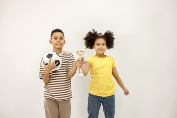 Multiracial boy and girl holding hands with winner cup