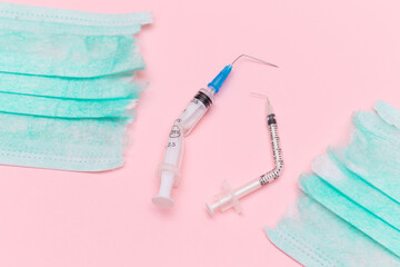 Anti Vaccine Movement and Anti Mask Concept - Broken Medical Syringe and Green Torn Medical Face Mask on the Pink Background. Pandemic and Lockdown End - Top View, Flat Lay