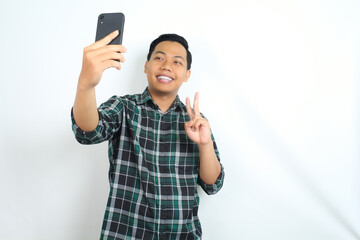 happy and attractive asian man take a selfie using smartphone isolated on white background