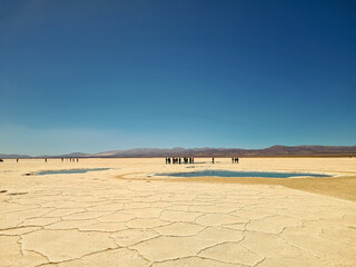 Tourists at a dry lake with layers of salt in northern Argentina