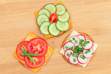 Different Cracker Sandwiches with Tomato, Cucumber, Radish and Cheese on Cutting Board. Easy Breakfast. Diet Food. Quick and Healthy Sandwiches. Crispbread with Tasty Filling. Healthy Dietary Snack