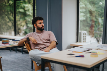 A thoughtful student sits in a bright classroom filled with study materials, suggesting focus and concentration on educational activities.