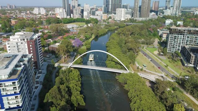 Aerial drone view above Parramatta River in Greater Western Sydney, NSW, Australia with Parramatta CBD in the background as a ferry travels to Parramatta Wharf  