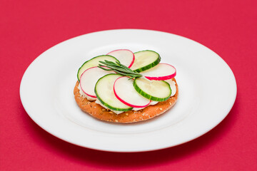 Crispy Cracker Sandwich with Cream Cheese, Fresh Cucumber and Radish on White Plate