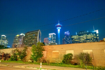 Calgary, Alberta. Downtown streets and buildings at night. Calgary Tower on the background