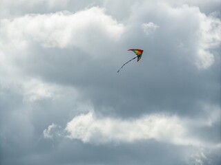 Minimalist Aesthetic of a Single Kite Gracefully Flying Against a Dramatic Cloudy Sky, Capturing the Essence of Freedom and Serenity in Nature's Embrace