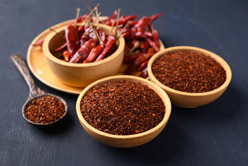 Red chili powder in bowl on black background, Food ingredient