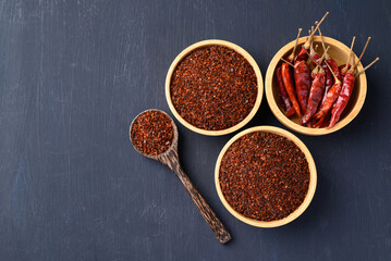Red chili powder in bowl on black background, Food ingredient, Top view