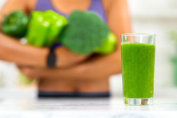 Healthy Smoothie. Unrecognizable african woman holding green vegetables, selective focus on blended...
