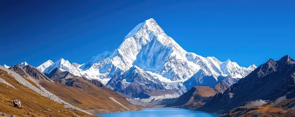 Majestic snow-capped mountain reflecting in a tranquil lake under a clear blue sky.