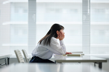 教室で考え事をする女子中学生
