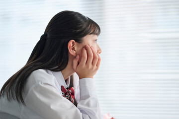 教室で考え事をする女子中学生