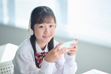 スマートフォンで授業を受ける女子中学生
