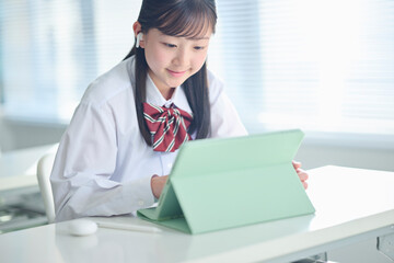 タブレット端末で授業を受ける女子中学生