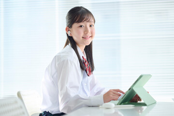 タブレット端末で授業を受ける女子中学生