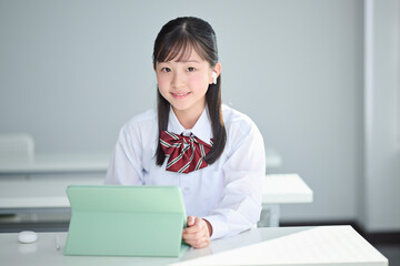 タブレット端末で授業を受ける女子中学生