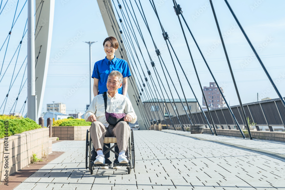 Leinwandbilder 介護、車椅子、ヘルパー、介護士、笑顔、歩道、外出、ボランティア、サポート、支援、高齢者、お年寄り、シニア、道路、屋外、リハビリ、女性、男性、日本人、サービス、デイサービス、ホームヘルパー、介護福祉士、老人ホーム、障害、障がい者、介護員、青空、元気、ポジティブ、街、都市、社会、橋、ウェルネス、健康、老後、バリアフリー、明るい、散歩、外出レク、福祉、介助、老人、押す、スタッフ、デイケア、施設、カメラ目