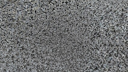 Black and white abstract pattern with a textured, organic feel. The image evokes a sense of depth and movement, with light and dark areas creating a dynamic.