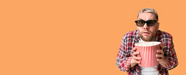 Emotional excitement from film. Funny guy hiding behind popcorn, panorama, free space