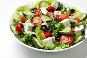 Delicious salad with feta cheese on white marble table, closeup
