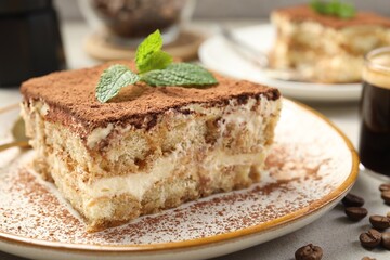 Piece of tasty tiramisu on beige table, closeup