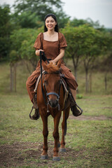 Fototapeta premium happy woman riding horse on meadow field