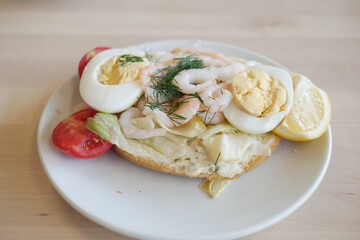 A Delicious and Savory Shrimp and Egg Sandwich Presented on a Plate with Fresh Vegetables