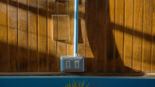 tomacorriente de 2 enchufes conectores a corriente de 220v  adosado a una pared de madera