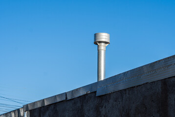 tubería de acero de la chimenea del techo. en el fondo se ve el cielo azul despejado