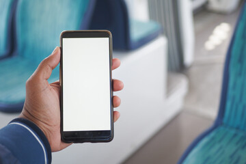 young man hand using smart phone with green screen inside of metro train
