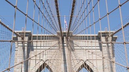 Fototapeta premium Brooklyn Bridge to Manhattan downtown, cables and blue sky. New York City iconic symbol, USA travel destination. Architecture of United States of America, tourist landmark. Famous cable-stayed bridge.