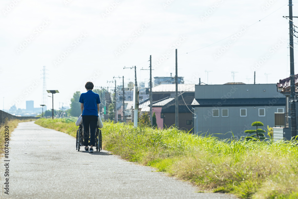Leinwandbilder 介護、車椅子、介護士、ヘルパー、後ろ姿、外出、屋外、歩道、サポート、デイサービス、シニア、高齢者、お年寄り、老人ホーム、施設、デイケア、レク、住宅街、公園、道、散歩、自然、青空、コピースペース、背中、福祉、ウェルネス、障害、障がい者、ボランティア、女性、男性、日本人、サービス、支援、フレイル、サルコペニア、哀愁、高齢化社会、老後、終活、ホームヘルパー、風景、広角、看護、見守り、介護福祉士、遠近感、