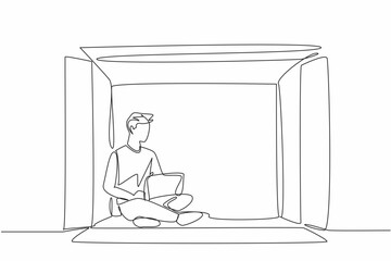 Single continuous line drawing of young man writing on laptop, inside big paper carton box. Work from home concept. Mental health issue. World Introvert Day. Frightened guy being outside box, social