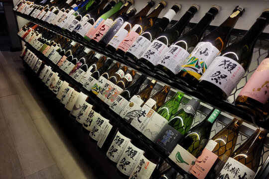 Penang, Malaysia - October 20, 2024: A display of assorted Japanese sake bottles arranged on shelves in a liquor store.
