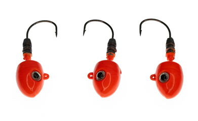 Three bright orange fishing jig hook heads with black eyes and sharp points
