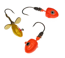 Three bright orange and yellow fishing jig hook heads with eyes and sharp points
