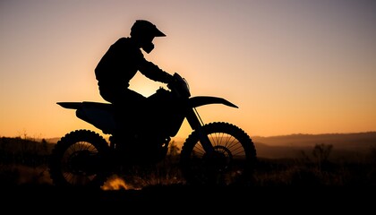 Silhouette of a trail motorbike rider in off-road terrain.