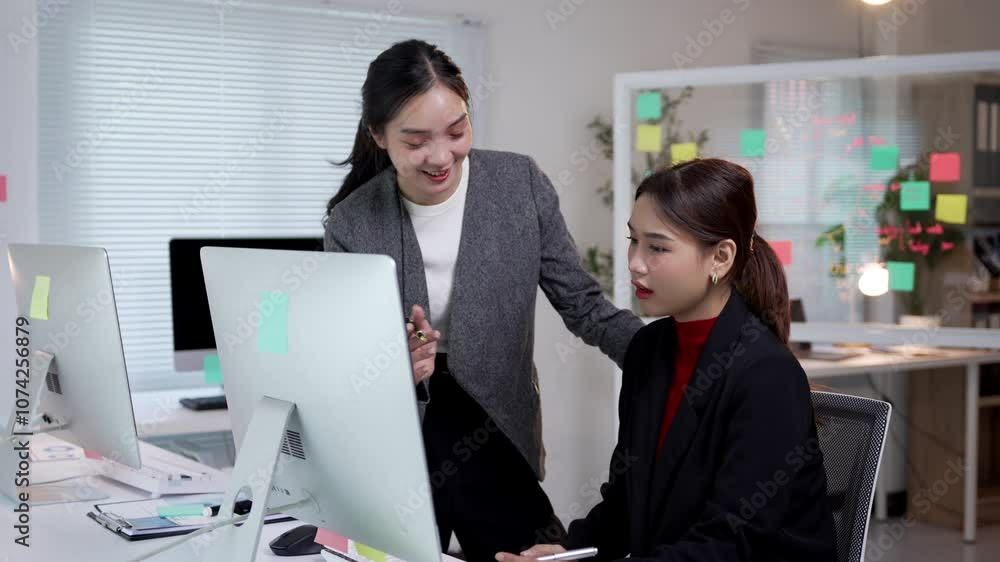 Poster manager showing a computer screen to an employee in a modern office, facilitating communication and 