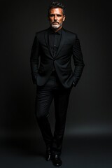 Obraz premium Full body of a very sexy man in his fifty in black suit stand in black background