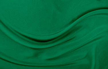 Black green satin dark fabric texture luxurious shiny that is abstract silk cloth background with patterns soft waves blur beautiful.