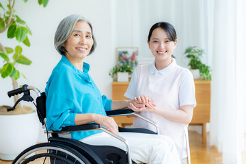 車椅子に乗った女性をサポートする介護士