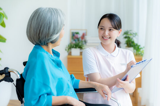 車椅子の女性をサポートする介護士