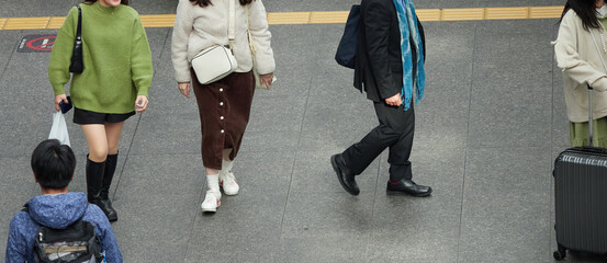 冬の名古屋駅の広場で歩く観光客と人々の姿